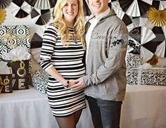 a man and woman standing next to each other in front of a table with black and white decorations