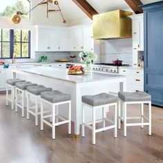 a kitchen with an island and six stools in front of the countertop area