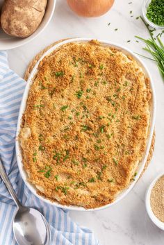 a casserole dish with parmesan cheese and green onions on the side