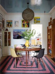 a dining room table with two chairs and a rug on the floor in front of it