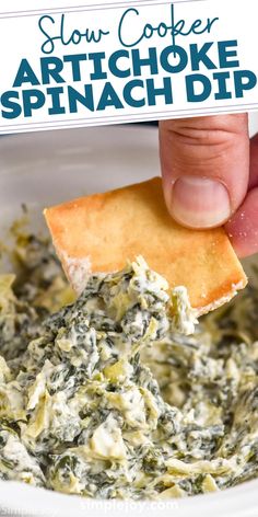 someone dipping spinach dip into a white bowl with crackers in it and text overlay reading slow cooker artichoke spinach dip