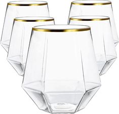 four clear glasses with gold rims on them