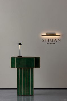 a table with a lamp on it in front of a sign that says shinan