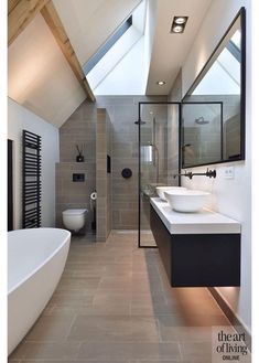 a bathroom with a skylight and two sinks in the center of the bathtub