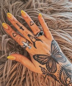 a woman's hand with tattoos on it