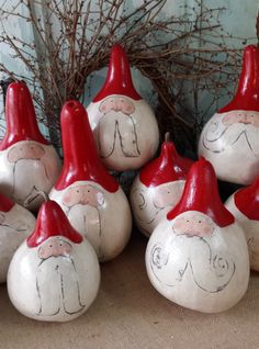 seven red and white ceramic gnomes with faces painted on them