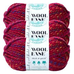 three skeins of wool ease yarn in red and pink