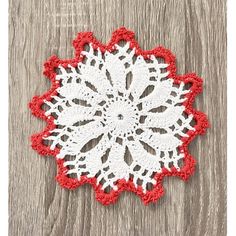 a red and white doily on a wooden surface