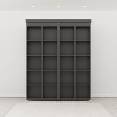 an empty room with a bookcase in the middle and a white wall behind it