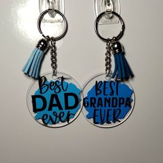 two key chains that have the words best dad and grandpa ever on them with tassels