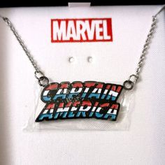 the captain america necklace is on display in front of a white shirt with red and blue letters