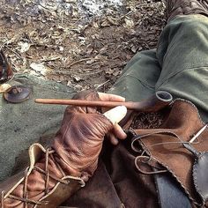 an old pair of boots is being used as a tool to repair the shoe laces on someone's feet