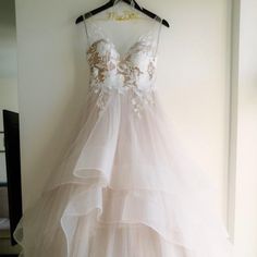 a wedding dress hanging up on a wall