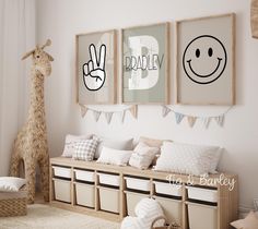 a child's room decorated in neutral tones with posters on the wall and stuffed giraffe