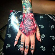 a woman's hand with tattoos on it and a rose tattooed on the wrist