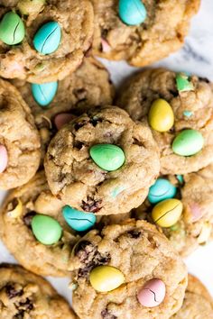 chocolate chip cookies with candy eggs and m & m's in the middle on a marble surface