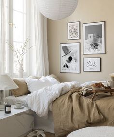 a bedroom with pictures on the wall above the bed and below the bed is a breakfast tray