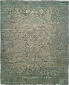 an antique rug with green and beige colors