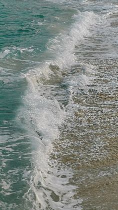 an ocean view with waves crashing on the shore