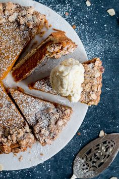 a plate with a pie and ice cream on it next to a spatula filled with powdered sugar