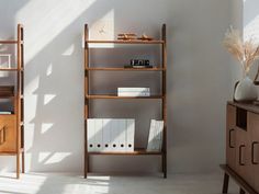 a book shelf with books on it next to a dresser