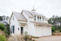 a large white house with two garages on the front and one above it's doors