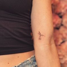 a woman's arm with a small tattoo on the left side of her body