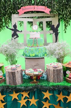 a table topped with cake and cupcakes on top of green cloth covered tables