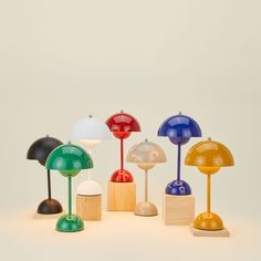 an assortment of different colored lamps on wooden bases