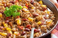 a bowl filled with chili and beans on top of a table