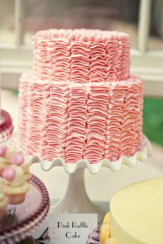 a pink cake sitting on top of a table