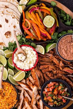 a platter filled with tacos, rice and other food items including meats