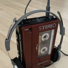 an old stereo with headphones attached to it on a wooden floor in front of a pair of headphones