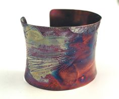 This etched copper cuff bracelet / bangle bearingflying ravens on a patterned swirling sky has been heat treated to create a vibrant multicoloured patina: this will deepen over time. I have developed a technique of literally 'painting' with a flame to manipulate the shape and direction of the colours. Although there is a degree of control, each piece is unique, as the colour patina cannot be replicated exactly. The beautiful anticlastic form in this version of my popular moongazing hare design i Artistic Patina Cuff Bracelet As Gift, Artistic Patina Cuff Bracelet Gift, Artistic Patina Bangle Bracelet, Artistic Bronze Cuff Bracelet Shaped As Bangle, Artistic Bronze Cuff Bracelet, Artistic Bronze Cuff Bracelet Bangle, Artistic Copper Cuff Bracelet, Artistic Copper Cuff Bracelet Bangle, Artistic Copper Cuff Bangle Bracelet