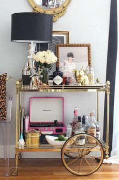 a gold bar cart with flowers and pictures on it