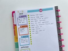 an open planner book with notes and stickers on the pages, sitting on a white surface