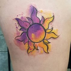 a watercolor sun tattoo on the back of a woman