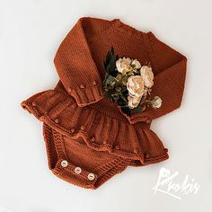 a knitted sweater and blooming bouquet on a white surface