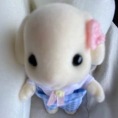 a small stuffed animal with a pink bow on it's head