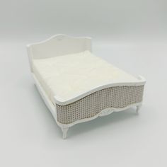 a small white bed sitting on top of a table