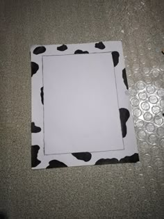 the paper has been cut out to make a cow print frame for the picture on the wall