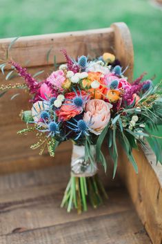 a bouquet of flowers sitting on top of a wooden bench