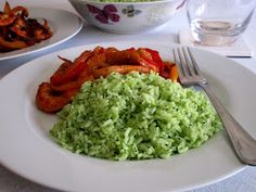 a white plate topped with rice and vegetables next to a bowl filled with meats