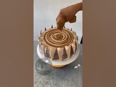 a person is decorating a cake with chocolate icing on the top and bottom