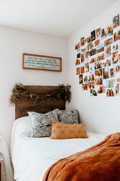 a bedroom with pictures on the wall above the bed and pillows in front of it