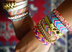 several different colored bracelets on someone's arm