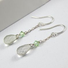 Elegant micro faceted pale mint green garnets have been wire wrapped by hand in sterling silver wire and added to a Green Swarovski crystal for that extra sparkle. These have been suspended from sterling silver chain to give swing to each earring. A sterling silver french earwire completes the piece. Garnet is the birthstone for January. The green garnets measure 70mm approx. Your earrings will arrive in one of my pretty gift bags ready to give. All orders are shipped with tracking. Thank you. Specifications: - garnet earrings - Swarovski crystal - Sterling silver earwires - Gift bag Sterling Silver Faceted Earrings For May Birthstone, Faceted Green Amethyst Earrings Gift, Silver Green Amethyst Earrings For Gift, Green Garnet, Garnet Earrings, Swarovski Crystal Earrings, Birthstone Earring, Swarovski Earrings, Pretty Gift