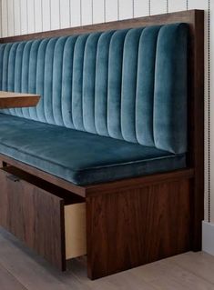 a wooden bench with blue velvet upholstered back