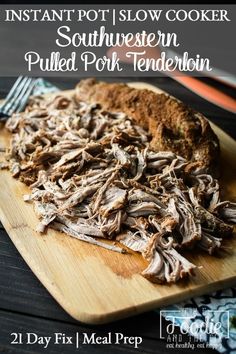 a wooden cutting board with pulled pork on it next to a fork and knife in the background