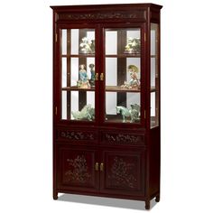 a wooden china cabinet with glass doors and carvings on the front, along with two figurines